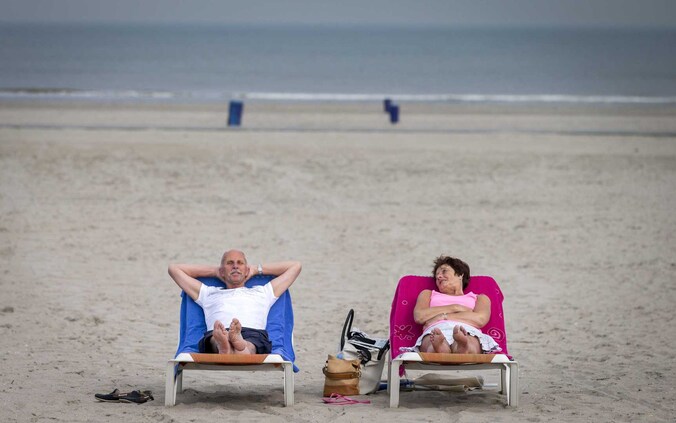 Toeristen op het strand van Hoek van Holland. Steeds meer Belgen trekken naar de Nederlandse kust.