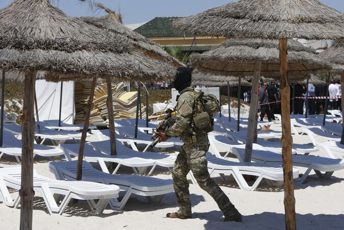 Een agent gisteren op het strand van het hotel in Sousse, vlak voor het bezoek van Britse, Franse, Duitse en Belgische vertegenwoordigers.
