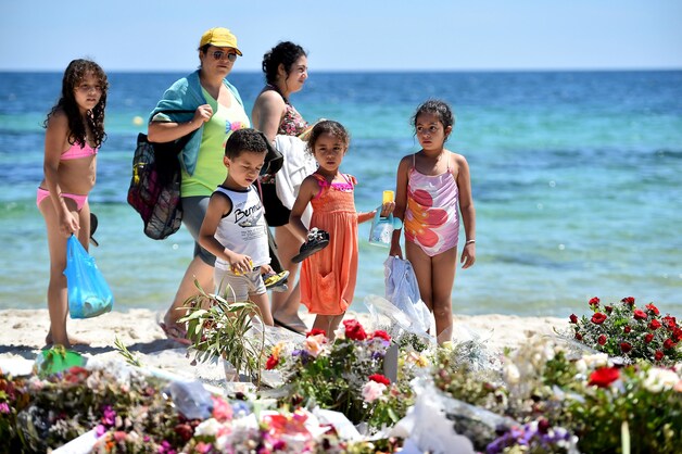 Op het strand in Sousse leggen heel wat mensen bloemen neer voor de slachtoffers.