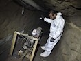 Een onderzoeker inspecteert een motor in een tunnel die 'El Chapo' gebruikt zou hebben om te ontsnappen.