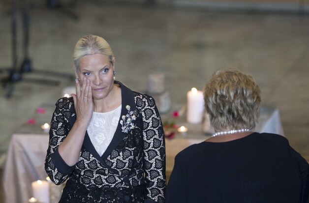 Kroonprinses Mette-Marit pinkt een traan weg tijdens een herdenkingsplechtigheid.