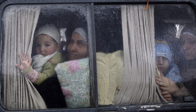 Syrische vluchtelingen die Idlib ontvlucht zijn met de bus.