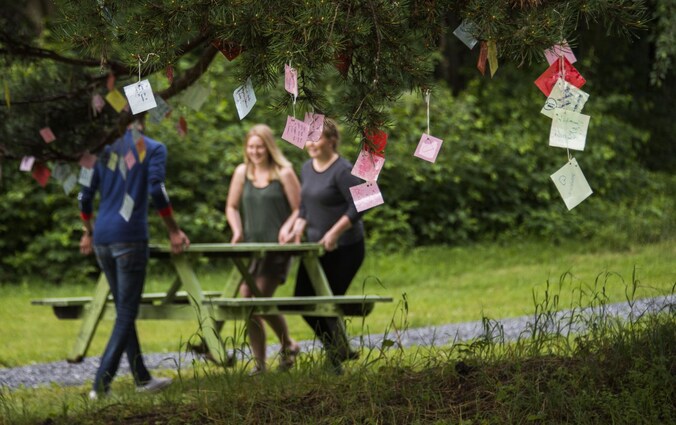 Jongeren treffen de nodige voorbereidingen voor het kamp. In de bomen hangen herinneringskaartjes voor de slachtoffers van de bloedige aanslag.
