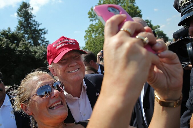 Een vrouw neemt een selfie met presidentskandidaat Donald Trump.