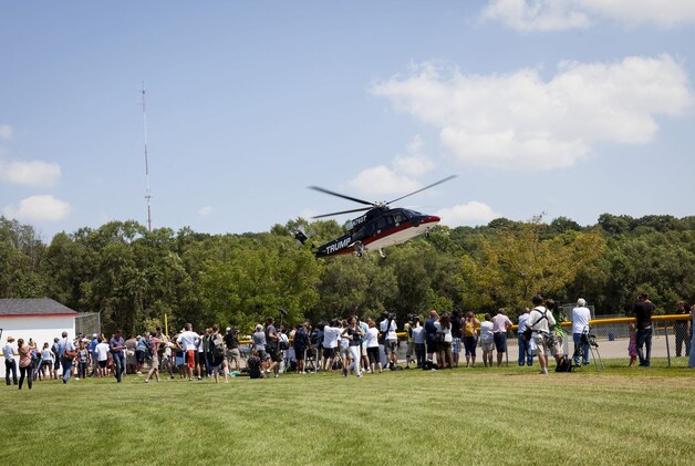 Aanhangers rennen naar de helikopter van Donald Trump.