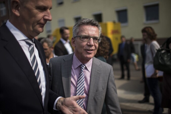 Duits minister van Binnenlandse Zaken Thomas de Maiziere (midden) bij een bezoek aan een asielcentrum nabij de Poolse grens.