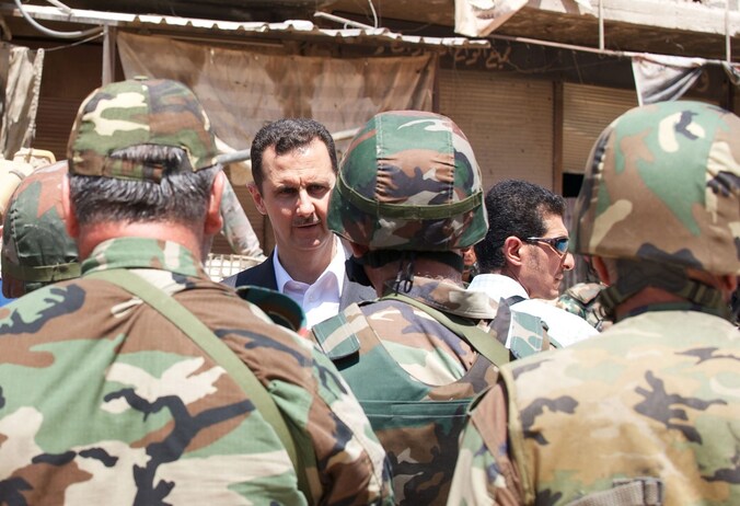 De Syrische president Bashar al-Assad tussen enkele Syrische militairen