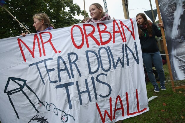 Militanten voeren actie tegen het hek dat Viktor Orban liet opstellen om vluchtelingen buiten de Hongaarse grenzen te houden.