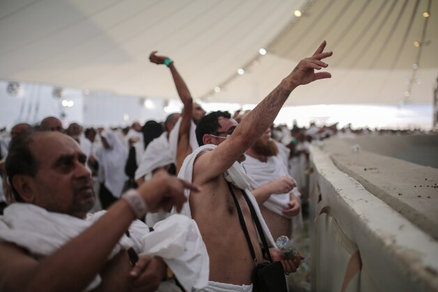 Pelgrims gooien stenen naar de pilaren van al-Jamarat.