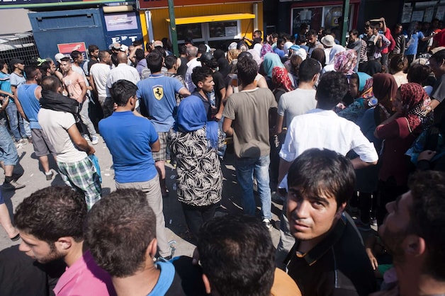 Duizenden migranten staan in de rij om een kaartje te kopen voor de ferry naar de haven van Piraeus in Athene.