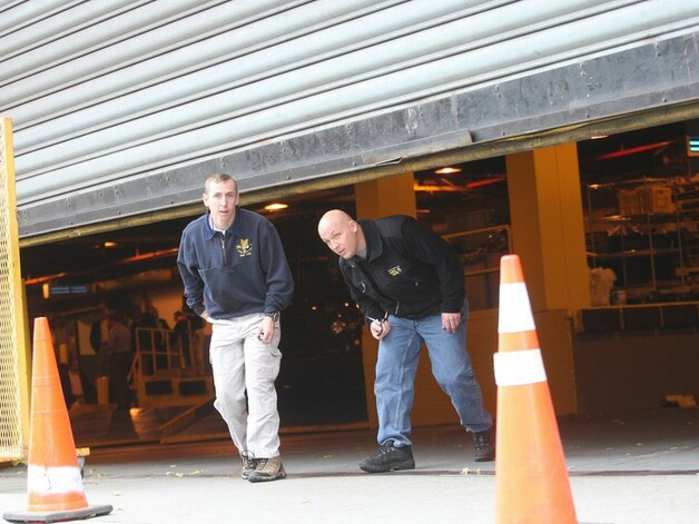 Agenten verlaten een garage in Brooklyn waar een vrachtwagen van UPS staat met een verdacht pakje.