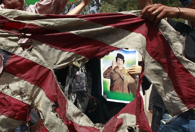 Medestanders van Kadhafi vernielen een Amerikaanse vlag.