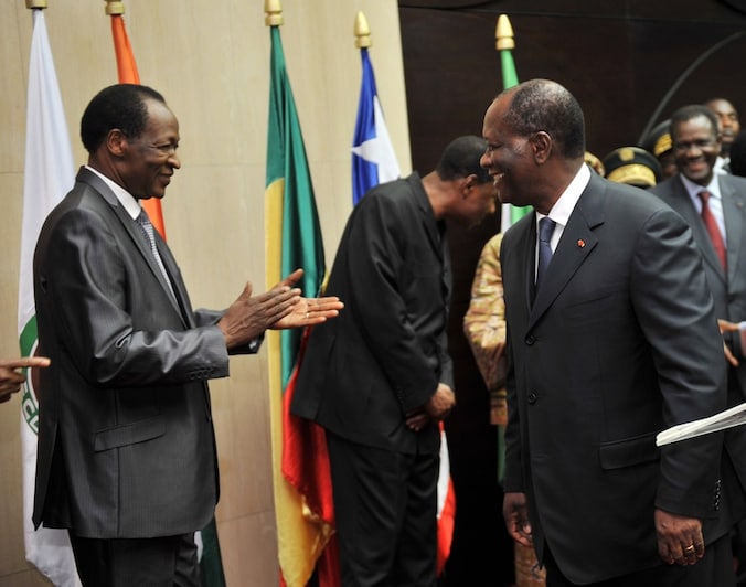 Blaise Compaore, president van Burkina Faso, heeft een beleefdheidsapplausje over voor Alassane Ouattara, president van Ivoorkust., na de ontmoeting van Ecowas.