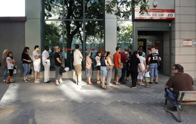 Spaanse werklozen wachten in de rij voor een arbeidsbemiddelingsbureau in Madrid.