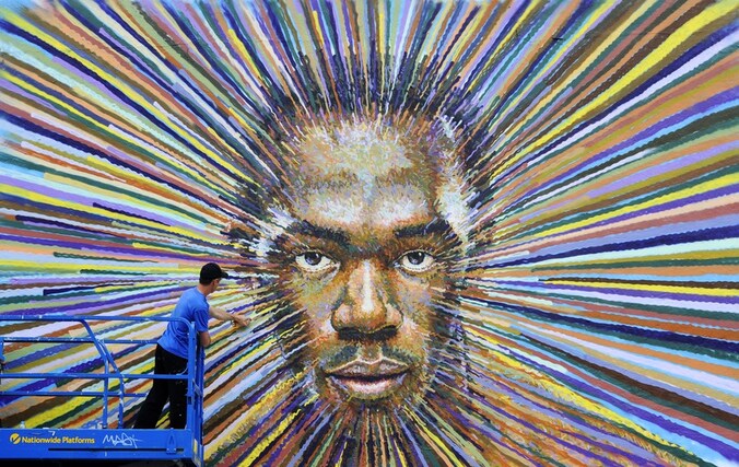 Graffiti-artiest James Cochran legt de laatste hand aan de beeltenis van het gezicht van Usain Bolt.