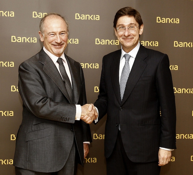 De voormalige Bankia-voorzitter Rodrigo Rato schudt de hand van zijn opvolger Jose Ignacio Goirigolzarri.