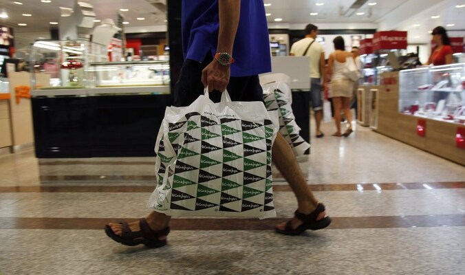 Een klant wandelt door het beroemde winkelcentrum El Corte Ingles in Madrid, dat prijzen moest verlagen en winstmarges verkleinen.