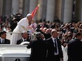 Paus Franciscus kust woensdag een baby tijdens een ritje over het Sint Pieterplein.