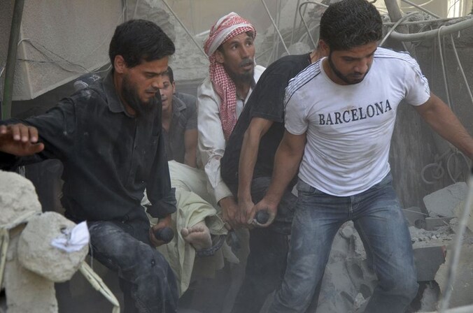 Een gewonde Syriër wordt weggedragen na een luchtaanval in de buurt van Damascus.