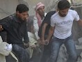Een gewonde Syriër wordt weggedragen na een luchtaanval in de buurt van Damascus.
