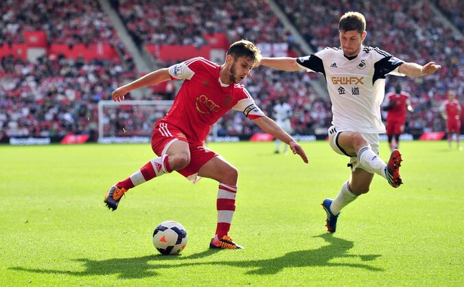Ben Davies (r) tracht Adam Lallana van Southampton af te houden.