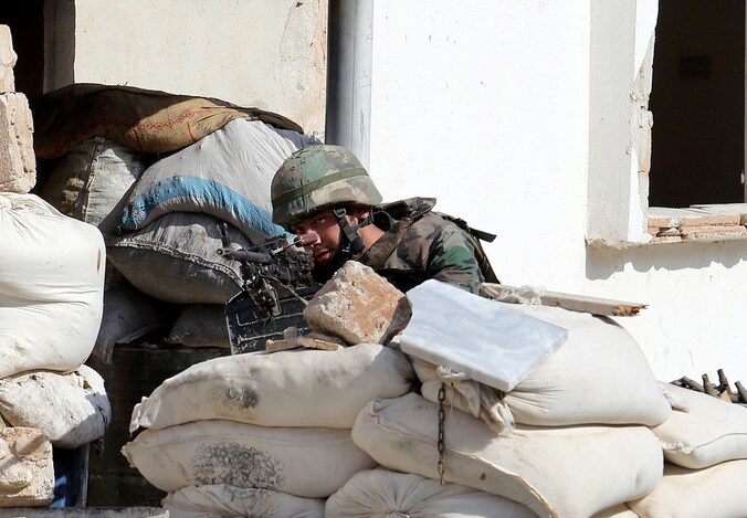 Een Syrische soldaat achter een barricade