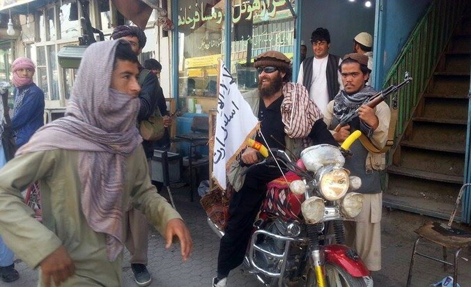 Een talibanstrijder in Kunduz heeft de witte vlag van de taliban aan zijn motor gehangen. (archieffoto 29 september 2015).