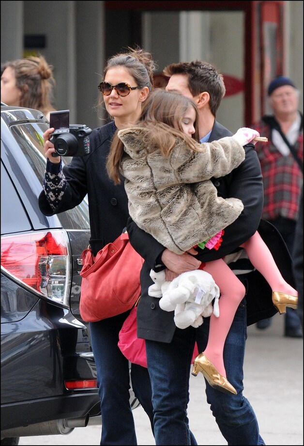 Suri Cruise met haar gouden hakjes in de armen van papa Tom.