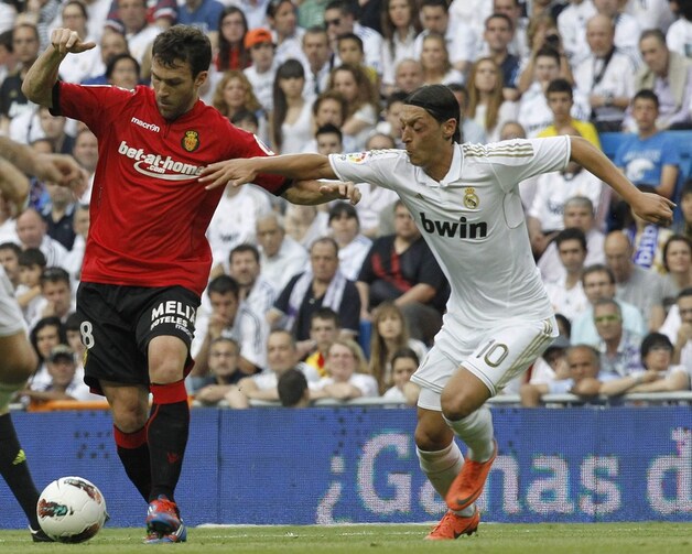 Nsue probeert Özil af te houden.