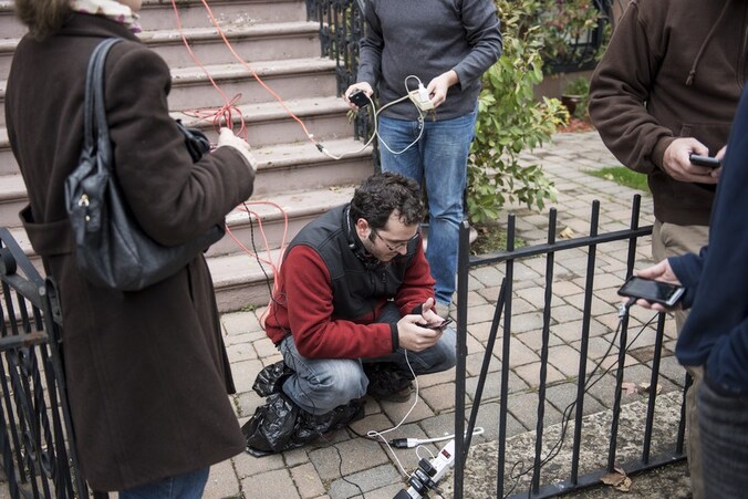 Inwoners van Hoboken in New Jersey laden hun gsm's op bij een huis dat nog stroom heeft.