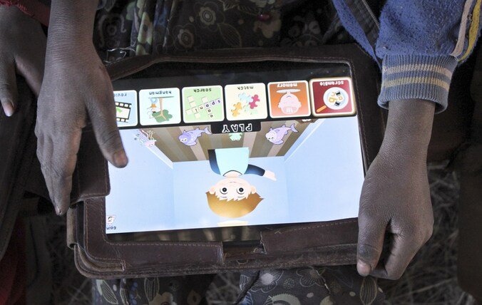 Een Ethiopisch kind probeert een (grotere) tablet van de organisatie.