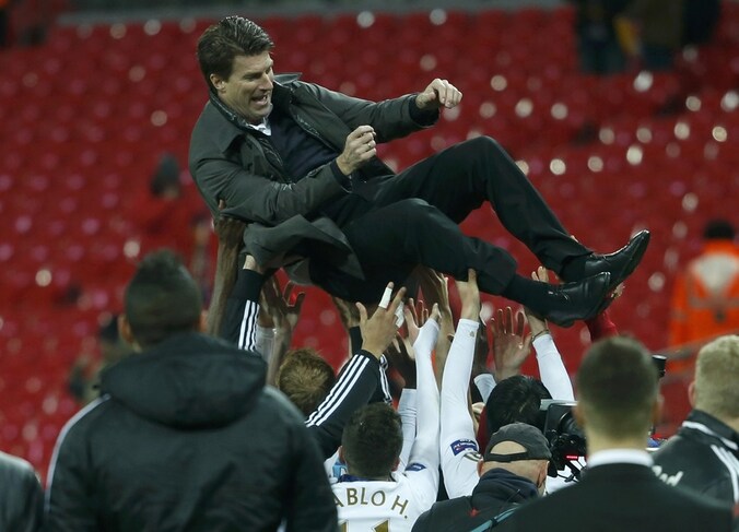 Laudrup wordt door de spelers van Swansea in de lucht gegooid na de zege in de League Cup.