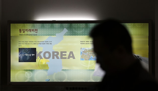 Een man passeert een kaart van het Koreaanse schiereiland bij de gedemilitariseerde zone tussen de twee Korea's.