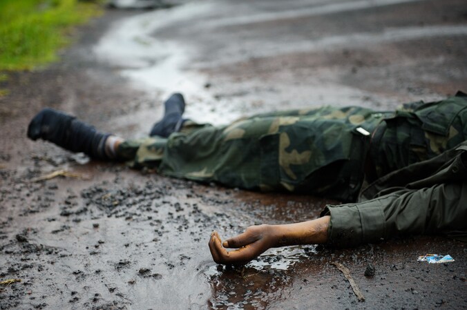 Het lichaam van een dode Congolese soldaat ligt op de weg tussen Goma en Kibati.