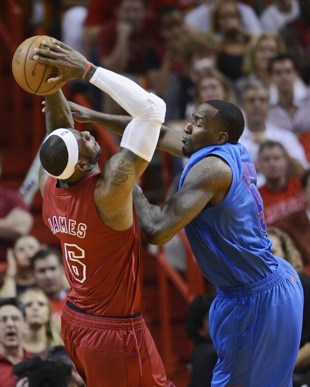 Perkins probeert LeBron James het scoren te beletten.