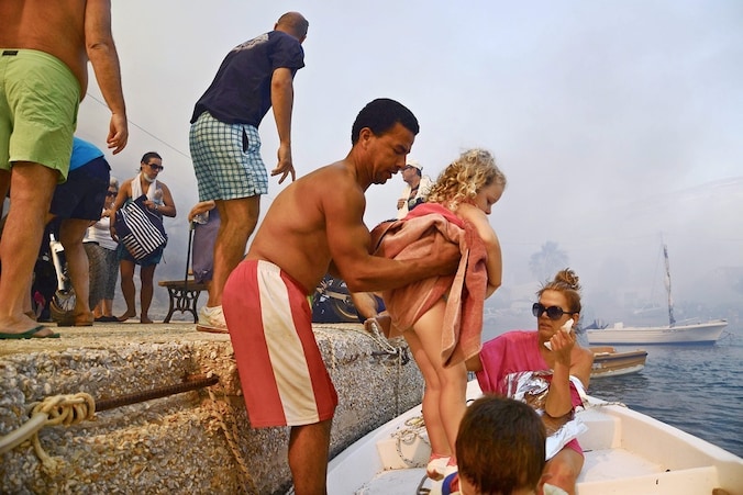 Toeristen en inwoners vluchte op het eiland Serifos, waar een bosbrand het plaatste Megalo Livadi naderde.