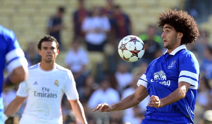 Marouane Fellaini controleert de bal op de borst, Pepe kijkt toe