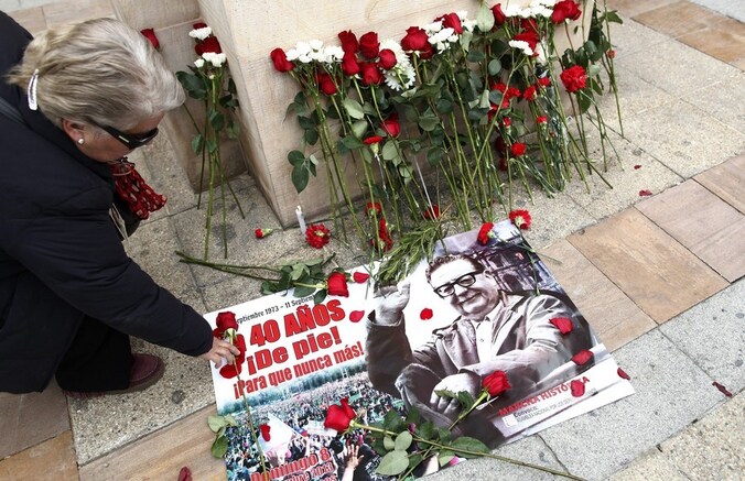 Een Chileense vrouw legt een roos op een afbeelding van president Salvador Allende, die 40 jaar geleden werd verdreven door een staatsgreep onder leiding van generaal Augusto Pinochet.