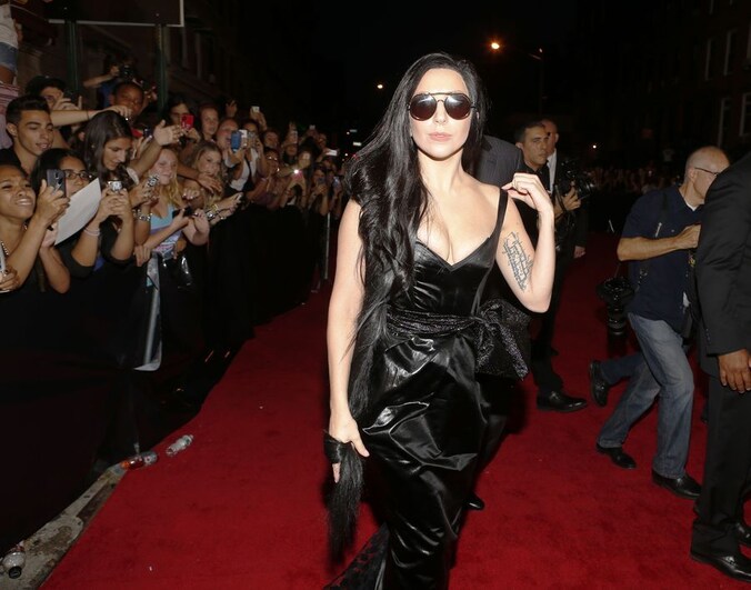 Op de cover zit Lady Gaga naakt met haar benen rond een glimmende blauwmetalen bal.