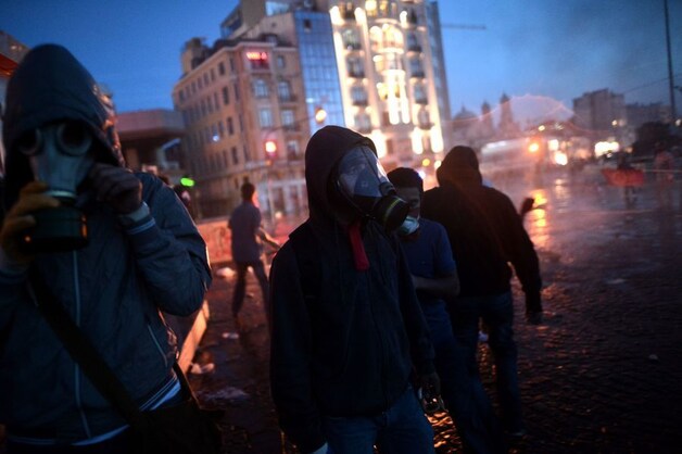 Demonstranten op het Taksim dragen gasmaskers tegen het traangas.