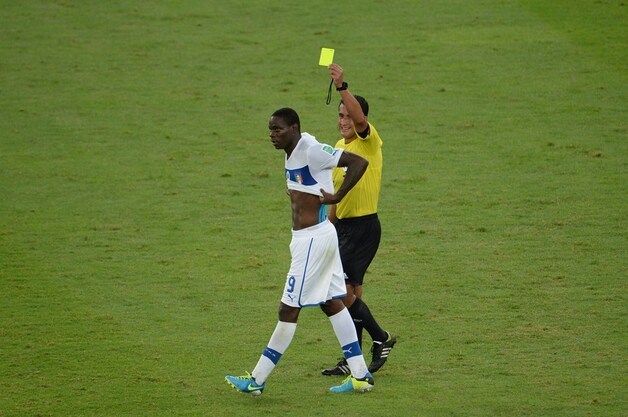 Mario Balotelli krijgt geel nadat hij, na zijn treffer tegen Mexico, zijn shirt heeft uitgetrokken.