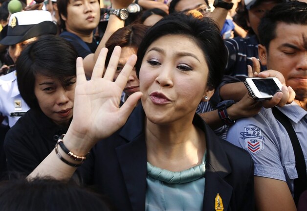 Yingluck Shinawatra tussen aanhangers nadat ze haar stem heeft uitgebracht.