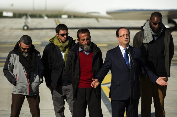 President Hollande hield een welkomstspeech voor de vrijgelaten gijzelaars die bij hem staan, eergisteren op een militair vliegveld even buiten Parijs. Marine Le Pen heeft gezegd dat ze verbaasd was over de baard en de kleding van de mannen. .