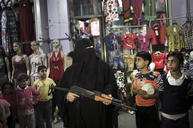 Een vrouw van Hamas houdt een geweer vast tijdens een protestactie na het overlijden van een Palestijnse gevangene in Israël.