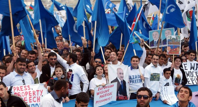 De oppositie uit Azerbeidzjan houdt postors omhoog tijdens een protestactie in Baku op 22 april.