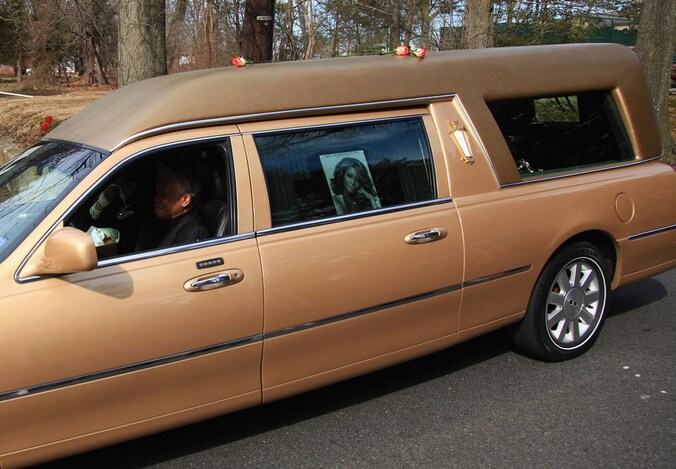 De kist werd vervoerd in een goudkleurige lijkwagen.