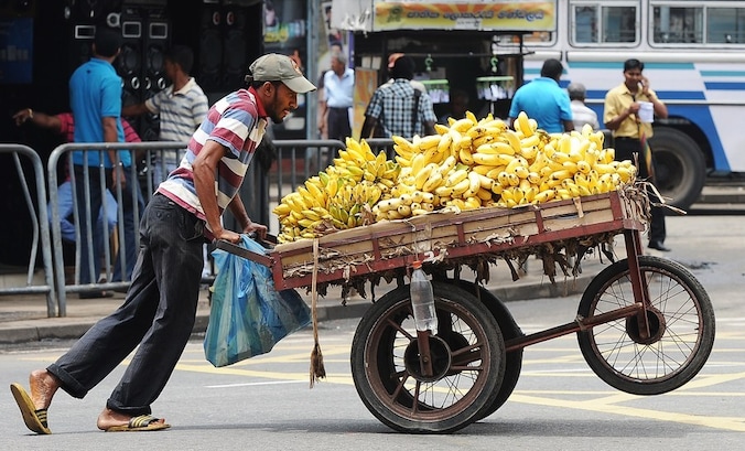 Een man met een bananenkar in Sri Lanka.