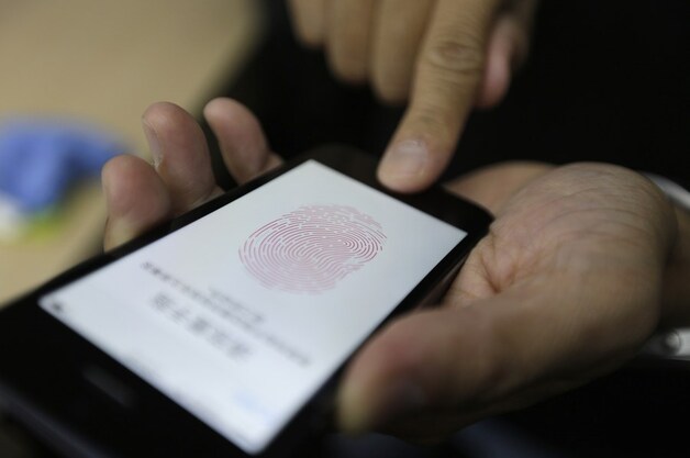 Een journalist test de vingerafdrukherkenning op de iPhone 5s.