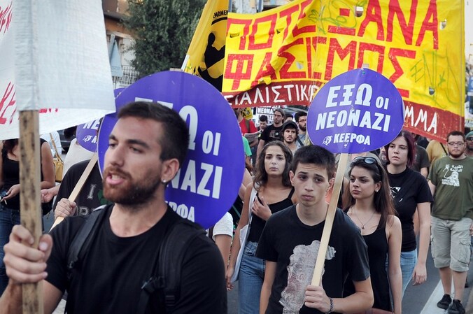 Anti-fascisme demonstranten in Athene dragen borden met het opschrift "Fascisme nooit meer opnieuw".
