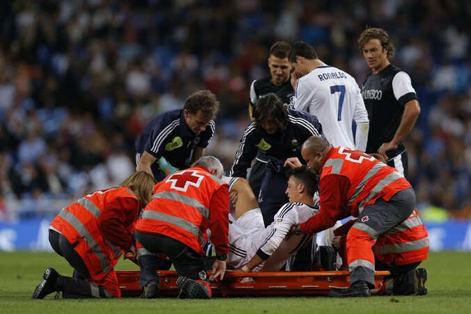 Mesut Özil verlaat het veld op de brancard.